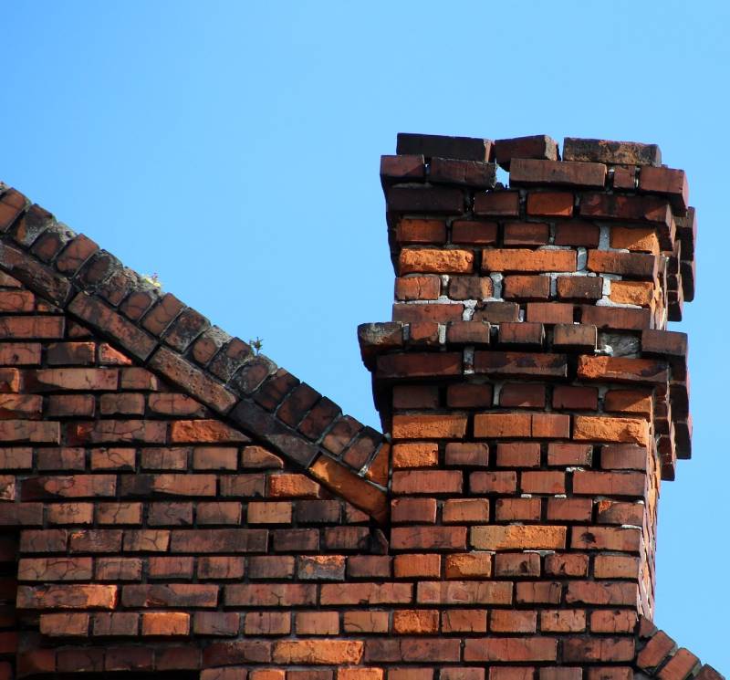 Damaged chimney on an Hamtramck home showing cracks and missing mortar